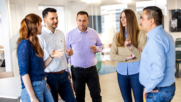 A diverse group of professionals having a discussion in a modern office setting