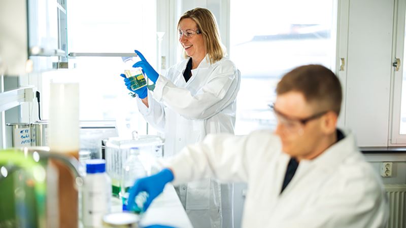 Pair of researchers in lab attire collaborating on a project in a lab