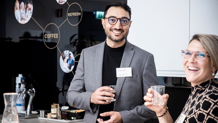 Two colleagues talking and smiling during a networking break at a Trelleborg leadership event