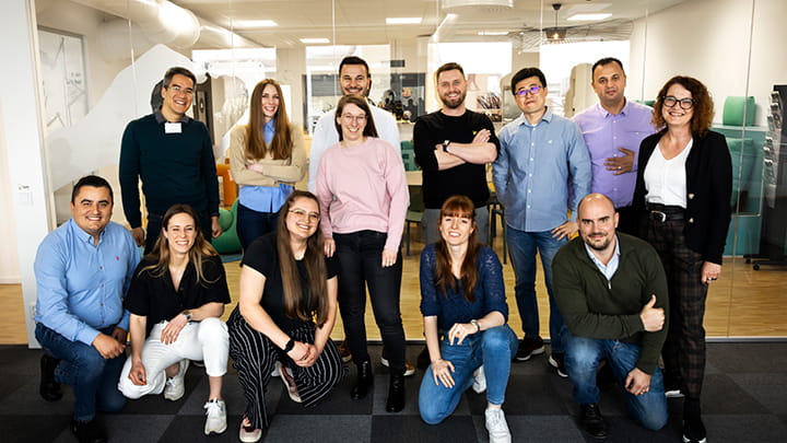 A cheerful group of Trelleborg  employees poses in the campus at the headquarter, representing the company's commitment to teamwork and community.