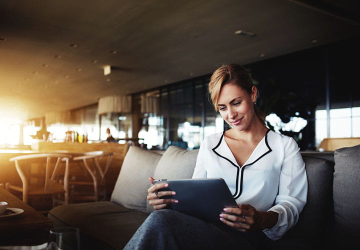 Woman sitting and reading news on tablet