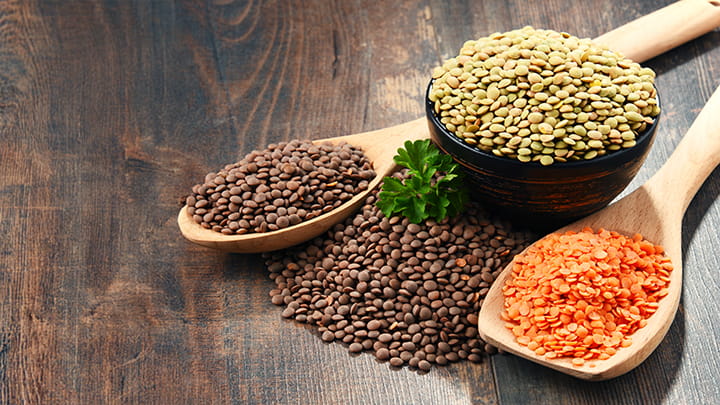 Composition with bowl of lentils on wooden table